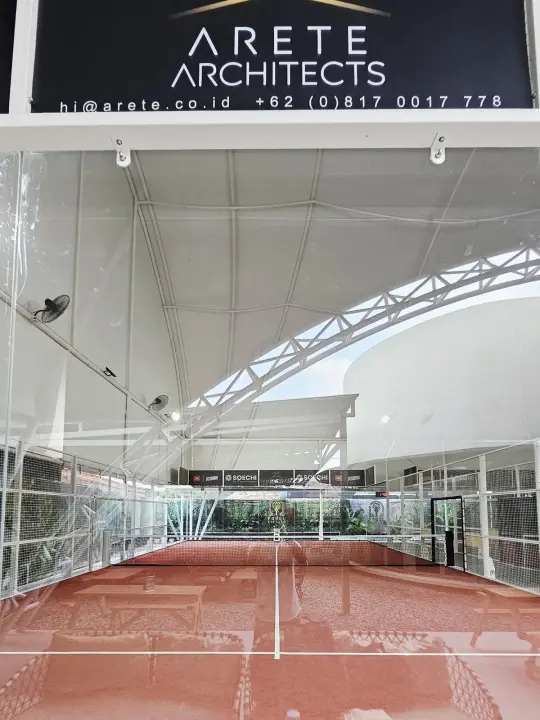 Terracotta court under the canopy with the Arete Architects banner