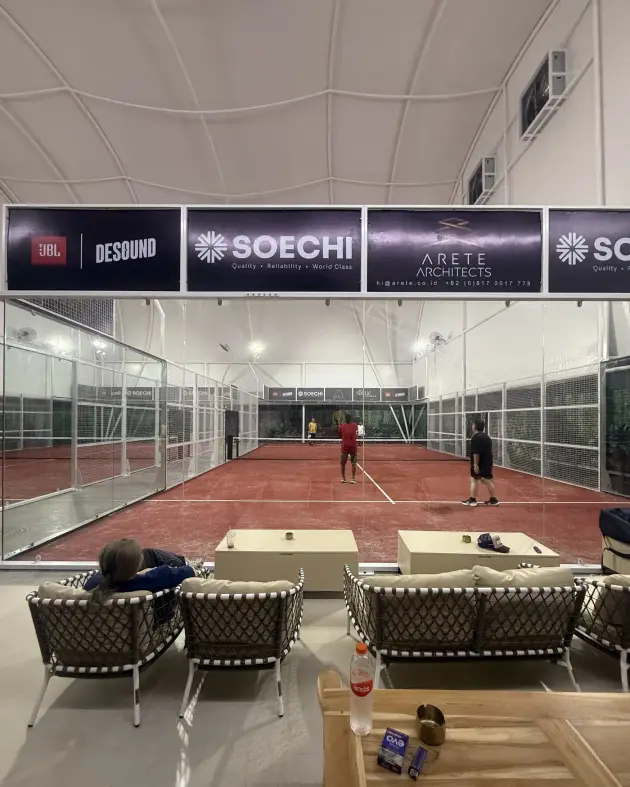 Courtside lounge with woven sofas facing the courts